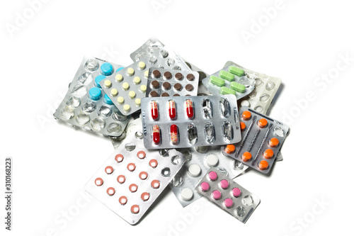 A pile of pills in blister packs. Blister packs full of multi-colored pills isolated on a white background.  Lot of tablets.