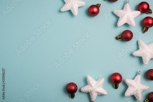 Christmas winter composition. Red balls with white stars canes on blue background. Top view, flat lay