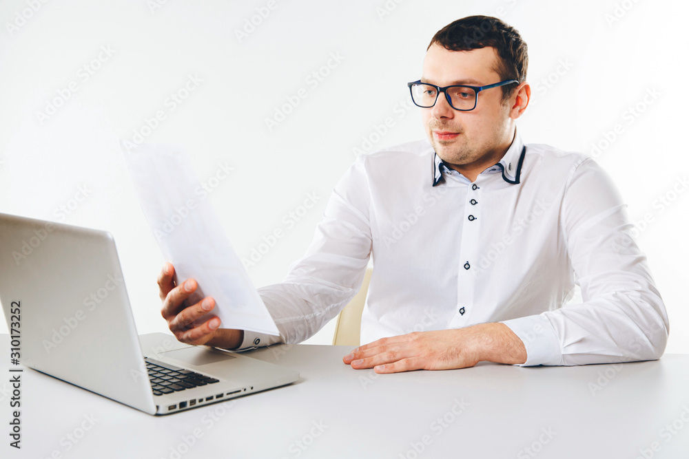 Man working with documents in office infront of the laptop Man working with documents in office infront of the laptop