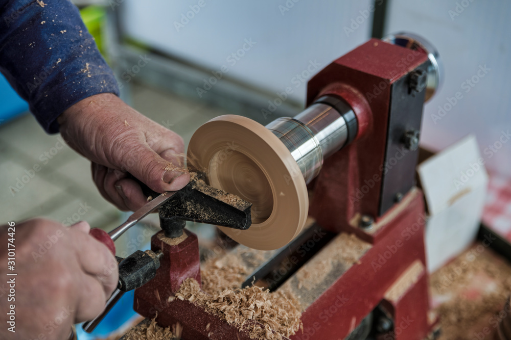 man turning wooden candle stands on a wood lathe man turning wooden candle stands on a wood lathe
