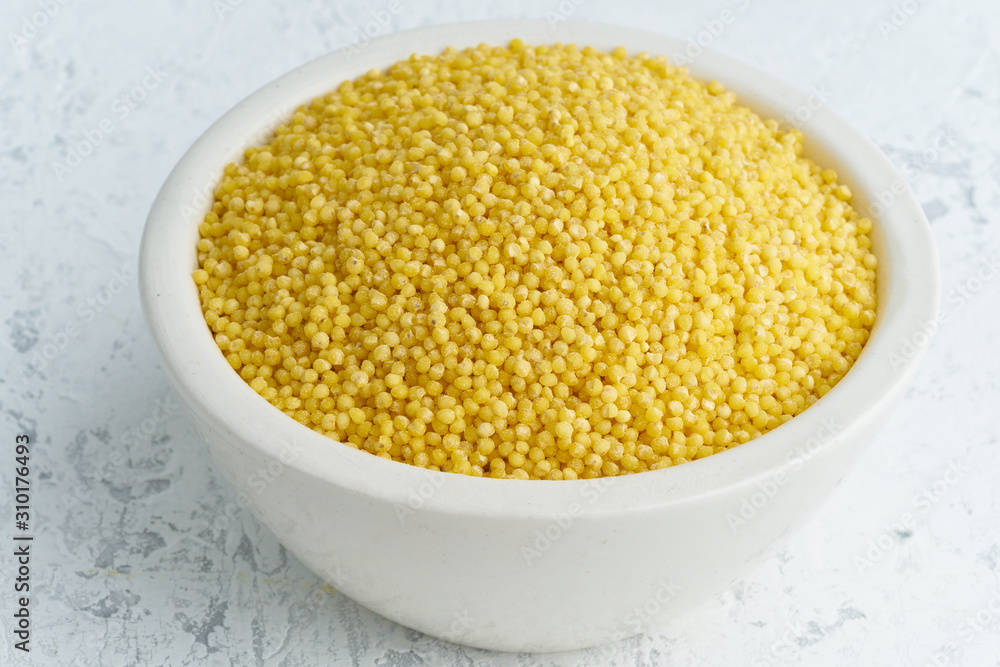 Millet, bulrush in white bowl on white background. Lectine free, dried
