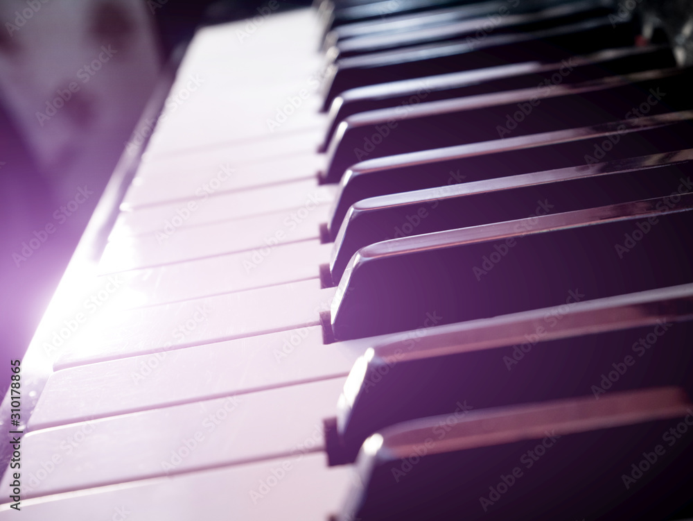 Old retro piano keys. close up view. Black and white keys, octave. Lighting effect