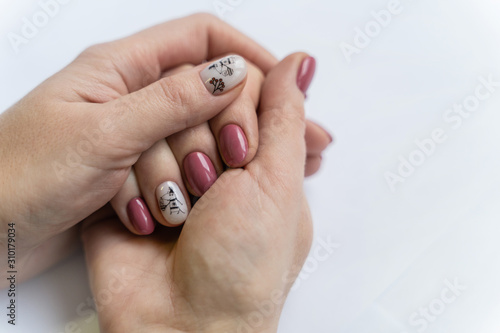 female hand with well-groomed nails with a Christmas sticker in the form of a mouse