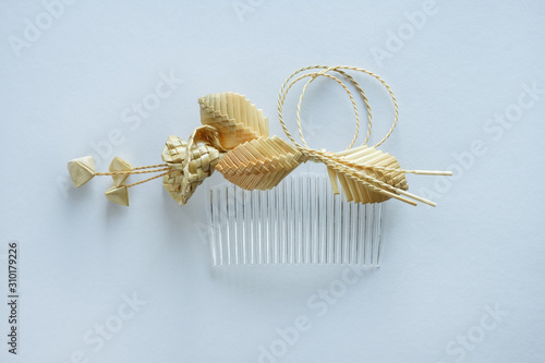Ornamental hair comb with straw flowers on a white background