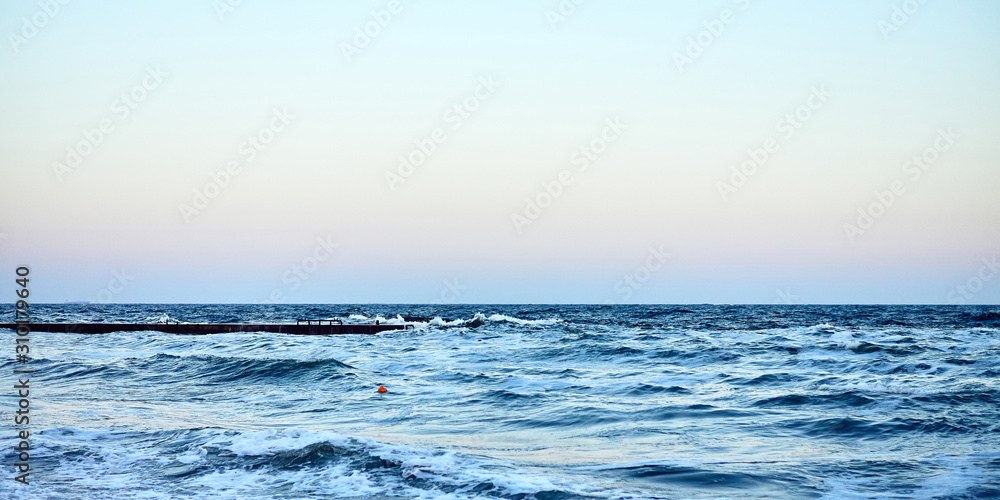 Panorama of soft focus bright blue waves on the background of clear sky. Seascape. Motion blur. 