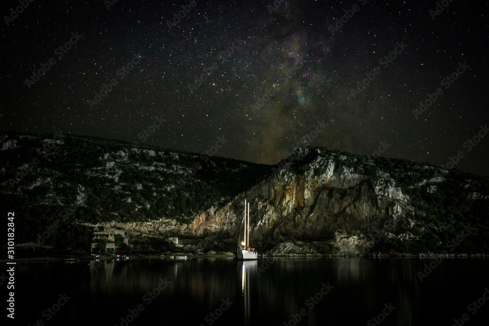 Sailing yacht at night in a quiet bay. The Milky Way is visible in the sky. Greece. Khalkidhiki