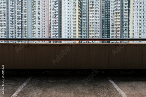 empty parking place in parkdeck with skyscraper buildings in background -