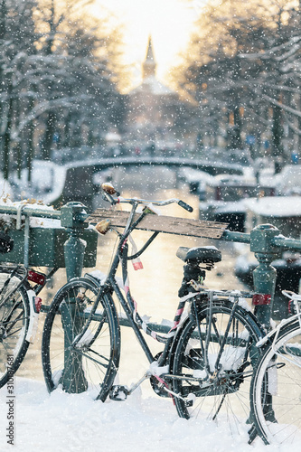 Photography Snow view of a Dutch canal with bicycles in the historic city of Amsterdam