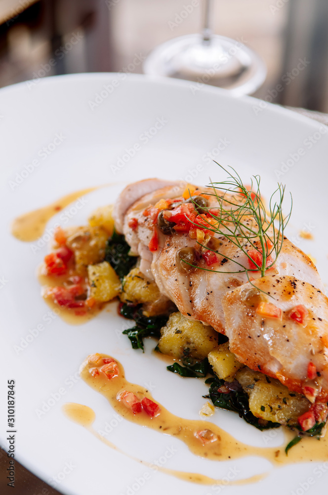 Grill chicken breast with baked potato and kale lemon butter sauce serving in white plate Grill chicken breast with baked potato and kale lemon butter sauce serving in white plate