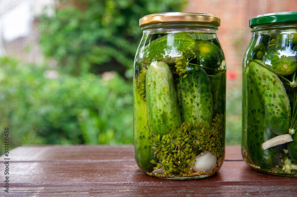 Homemade marinated cucumbers in glass jars on the table. Homemade marinated cucumbers in glass jars on the table.
