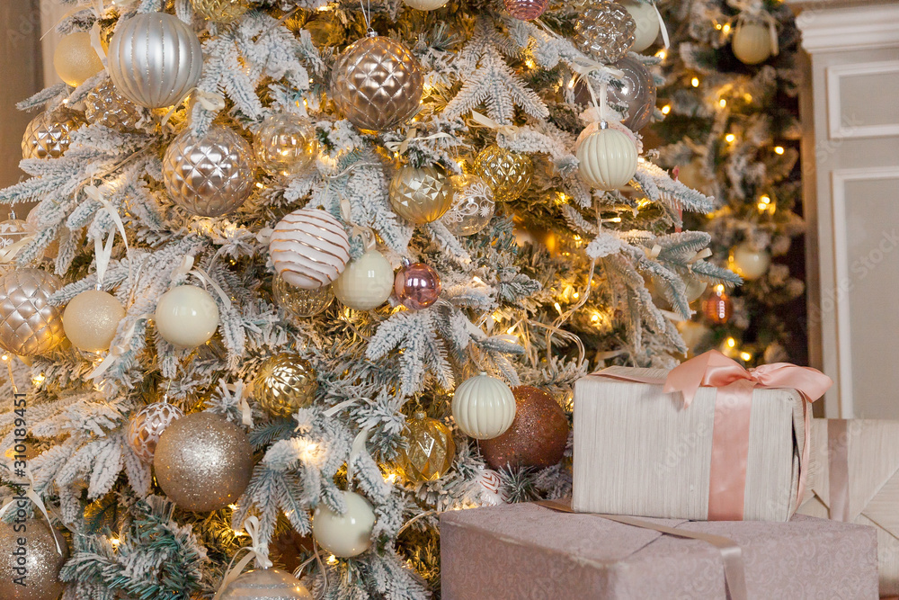 Obraz premium Christmas tree with lots of toys and Christmas lights with gifts under the tree