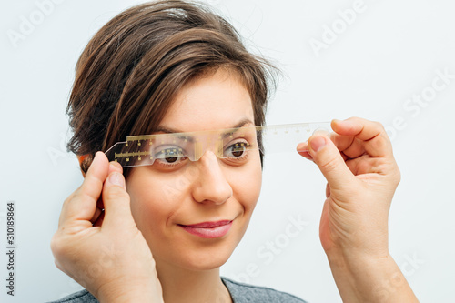smiling woman in optical trial frame on light gray background