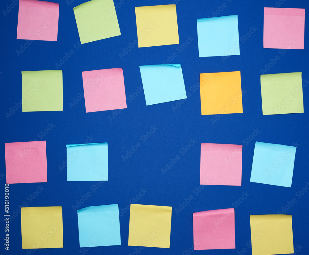 many glued square multi-colored blank stickers on a blue background