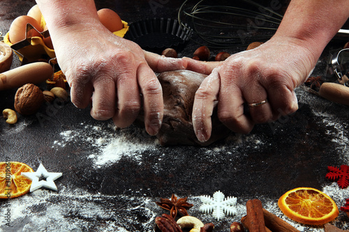 .Hands kneading dough. Baking christmas cookies. Typical cinnamon stars bakery with spices. xmas decoration on table