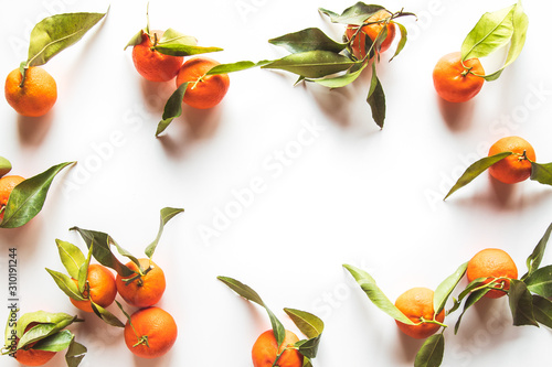 Fototapeta Naklejka Na Ścianę i Meble -  Oranges fruits composition with green leaves and slice on white wooden background, top view