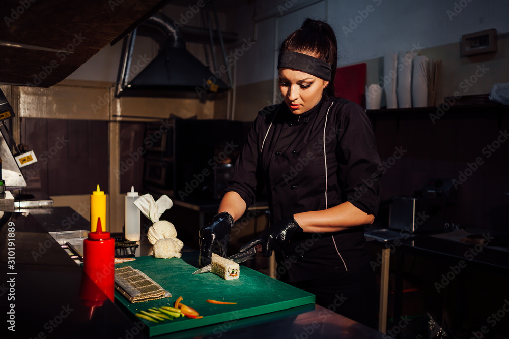 woman chef iprepares sushi restaurant in the kitchen