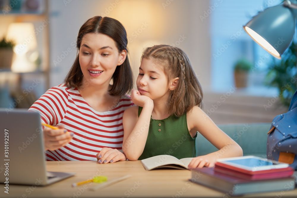 Girl doing homework with mother Girl doing homework with mother