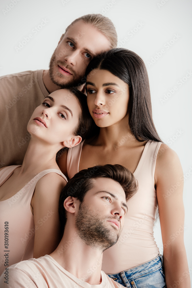young multicultural men and women in beige outfit posing together isolated on white