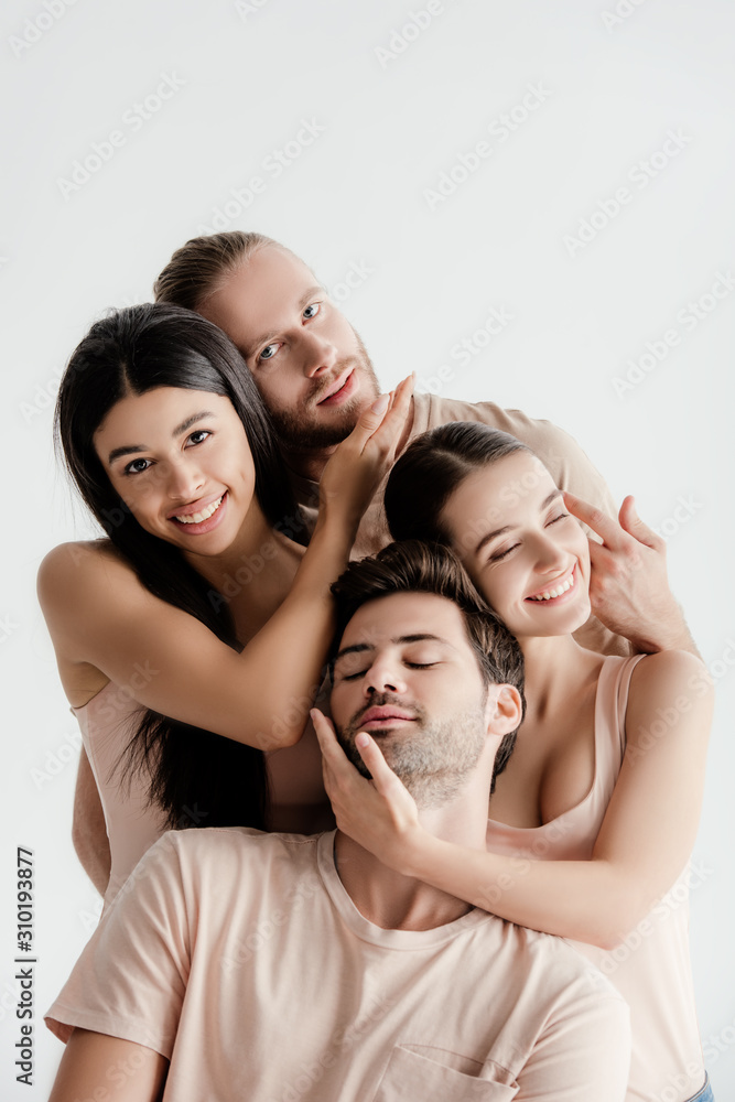 smiling young multicultural men and women in beige outfit posing together and touching faces isolated on white smiling young multicultural men and women in beige outfit posing together and touching faces isolated on white