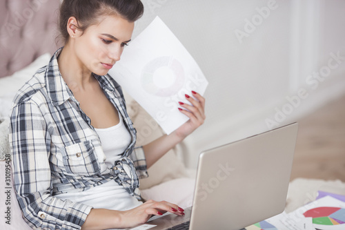 Young attractive woman working at laptop photo