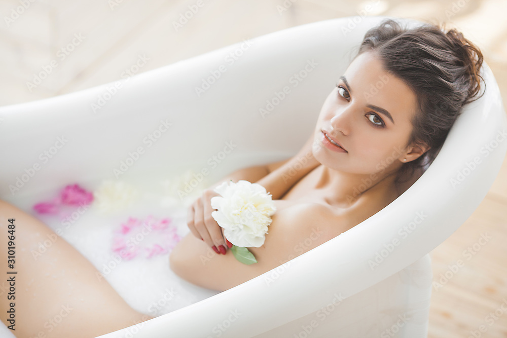 Obraz premium Perfect woman bathing with flowers and milk