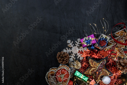 Christmas decoration. Twigs christmas tree, brown natural pine cones and and Xmas deer with variety of fruits on dark background. copy space.