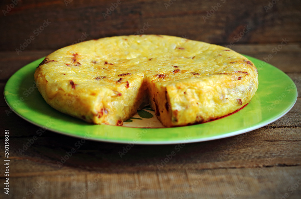 Potato omelette on a plate on wooden background