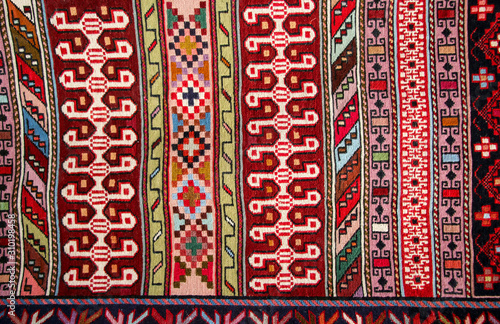 Old traditional carpet with a geometric pattern blue, white and dark red colors in arabic style on bazaar in Mostar, Bosnia and Herzegovina