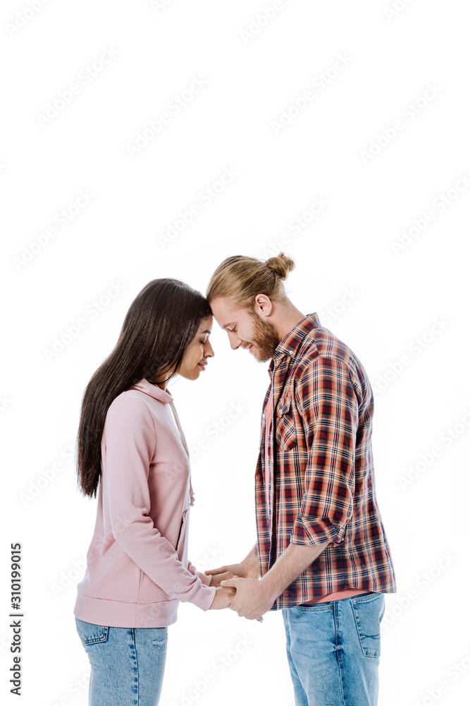side view of happy young interracial couple holding hands with closed eyes isolated on white side view of happy young interracial couple holding hands with closed eyes isolated on white