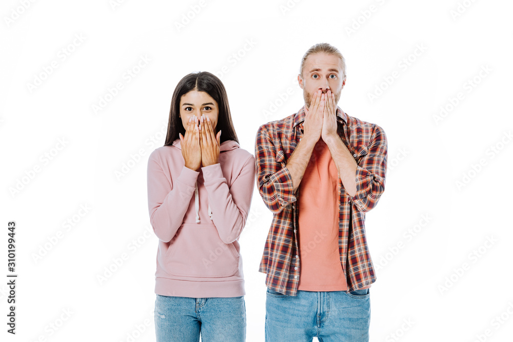 shocked young interracial couple covering mouths with hands isolated on white shocked young interracial couple covering mouths with hands isolated on white