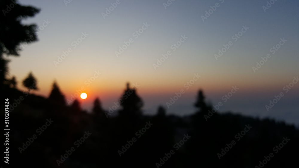 Blurred sunset from a mountain's peak above the clouds
