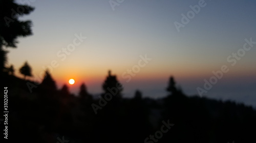 Blurred sunset from a mountain s peak above the clouds
