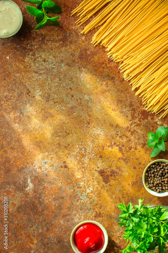 pasta raw, spaghetti or bucatini and tomato sauce ingredients. food background. copy space photo