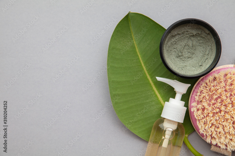 Organic natural cosmetic product with a green leaf on a grey background