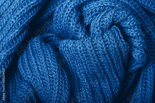 Knitted scarf texture. Classic blue color. The concept of cozy, comfort, warm, softness or winter
