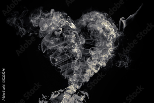 There is heart made of smoke on the black background.