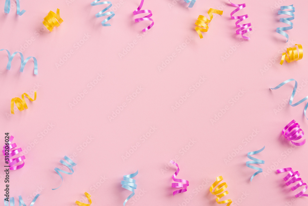 Colorful serpentine on pink  background. Flat lay, top view, copy space.