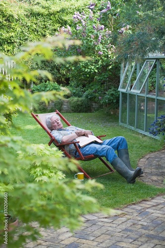 Senior Man Sleeping On Deckchair In Backyard © moodboard