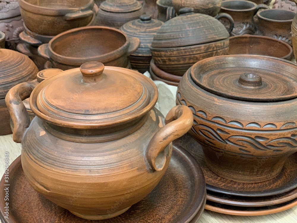 Brown ceramic dishes in a shop window. Clay pots, plates and handmade cups. Brown ceramic dishes in a shop window. Clay pots, plates and handmade cups.