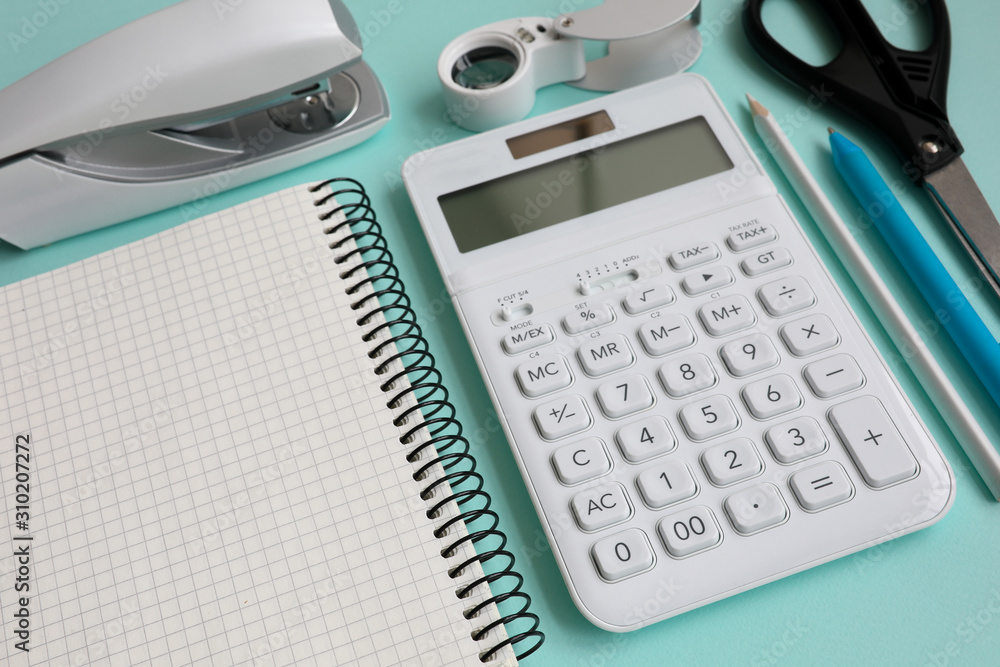 Stationery with white calculator lie on blue table epty modern Stationery with white calculator lie on blue table epty modern