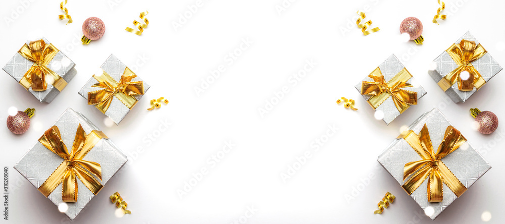 Obraz premium New years background. Christmas gifts with gold ribbon on white background. Xmas present. Winter holiday concept. Merry Christmas and Happy Holidays greeting card, frame, banner
