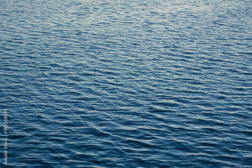 Infinite background of water waves in lake. Blue to black colors. Natural texture. Infinite background of water waves in lake. Blue to black colors. Natural texture.