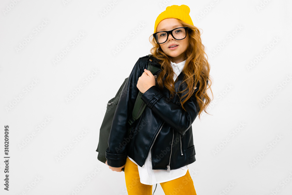 Teenager caucasian girl with yellow hat holds a big backpack in her hands isolated on white background Teenager caucasian girl with yellow hat holds a big backpack in her hands isolated on white background