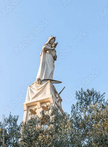 Statue of the Mother of God with a baby in her arms on the roof of the Our Lady of the Ark of the Covenant Church in the Chechen village Abu Ghosh near Jerusalem in Israel photo