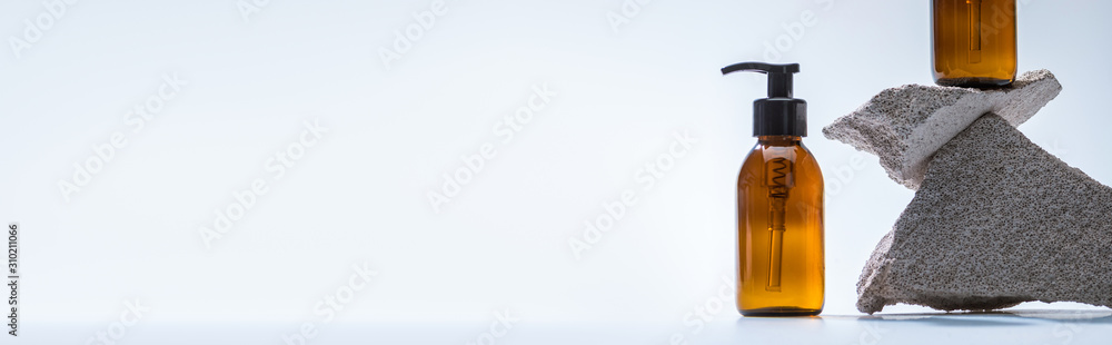 dispenser cosmetic bottles with stones on white background with back light, panoramic shot dispenser cosmetic bottles with stones on white background with back light, panoramic shot