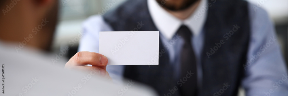 Male arm in suit give blank calling card to visitor Male arm in suit give blank calling card to visitor