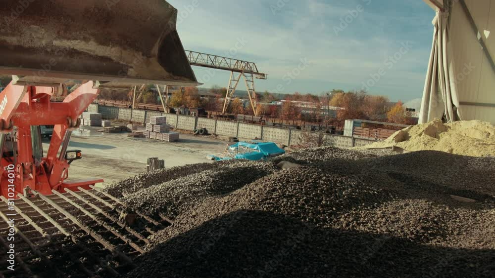 Picture of the whole bucket as its dropping product by tractor. It is a