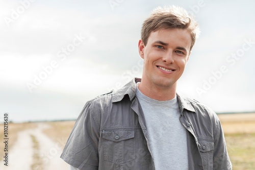 Portrait of handsome young man standing on field