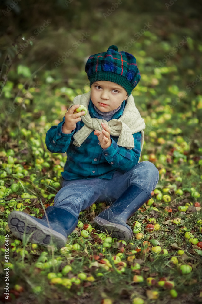 Boy 5-7 years in the fresh nature in rubber boots and autumn clothes walking in the woods. Boy 5-7 years in the fresh nature in rubber boots and autumn clothes walking in the woods.