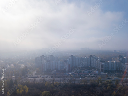Foggy morning above city district.